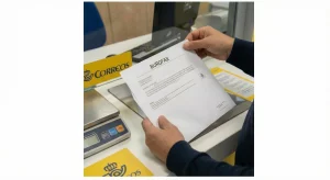 Persona en una oficina de Correos enviando un burofax para notificar la subrogación del contrato de alquiler por fallecimiento del titular.